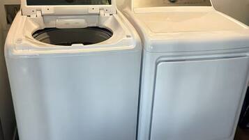 A front-loading washing machine and dryer side by side in a laundry room with a tiled floor.