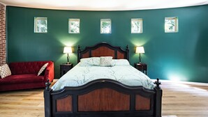 A bedroom with a wooden bed, a red sofa, and four wall-mounted picture frames. - Charm of Crestview! 5-bedroom house in serene Knoxville! (Knoxville)