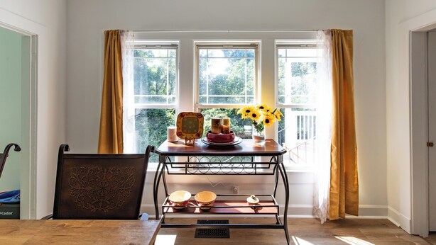 A room with a dining table, chairs, a metal shelf, and a window with curtains. - Charm of Crestview! 5-bedroom house in serene Knoxville! (Knoxville)