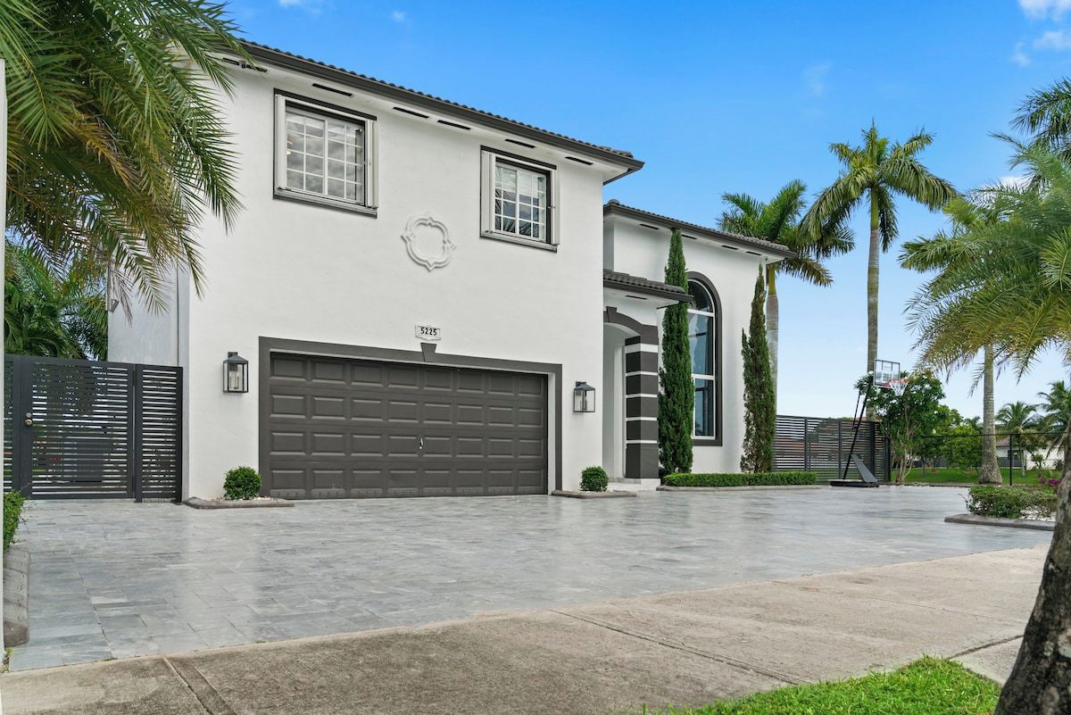 A modern two-story house with a garage, a driveway, and a well-maintained lawn.