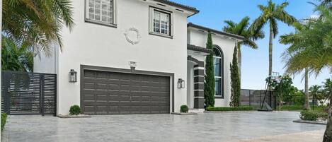 A modern two-story house with a garage, a driveway, and a well-maintained lawn.