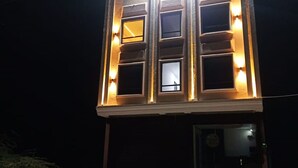 Un bâtiment doté de fenêtres illuminées et d’un balcon.