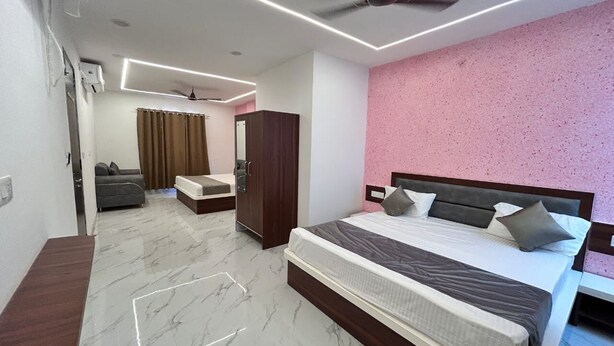 Une chambre moderne dotée d’un grand lit, d’une armoire, d’un coin salon et d’un ventilateur de plafond.