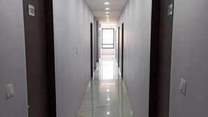 Un long couloir étroit, avec des portes des deux côtés, numérotées 105 et 104, qui donnent accès à des pièces.