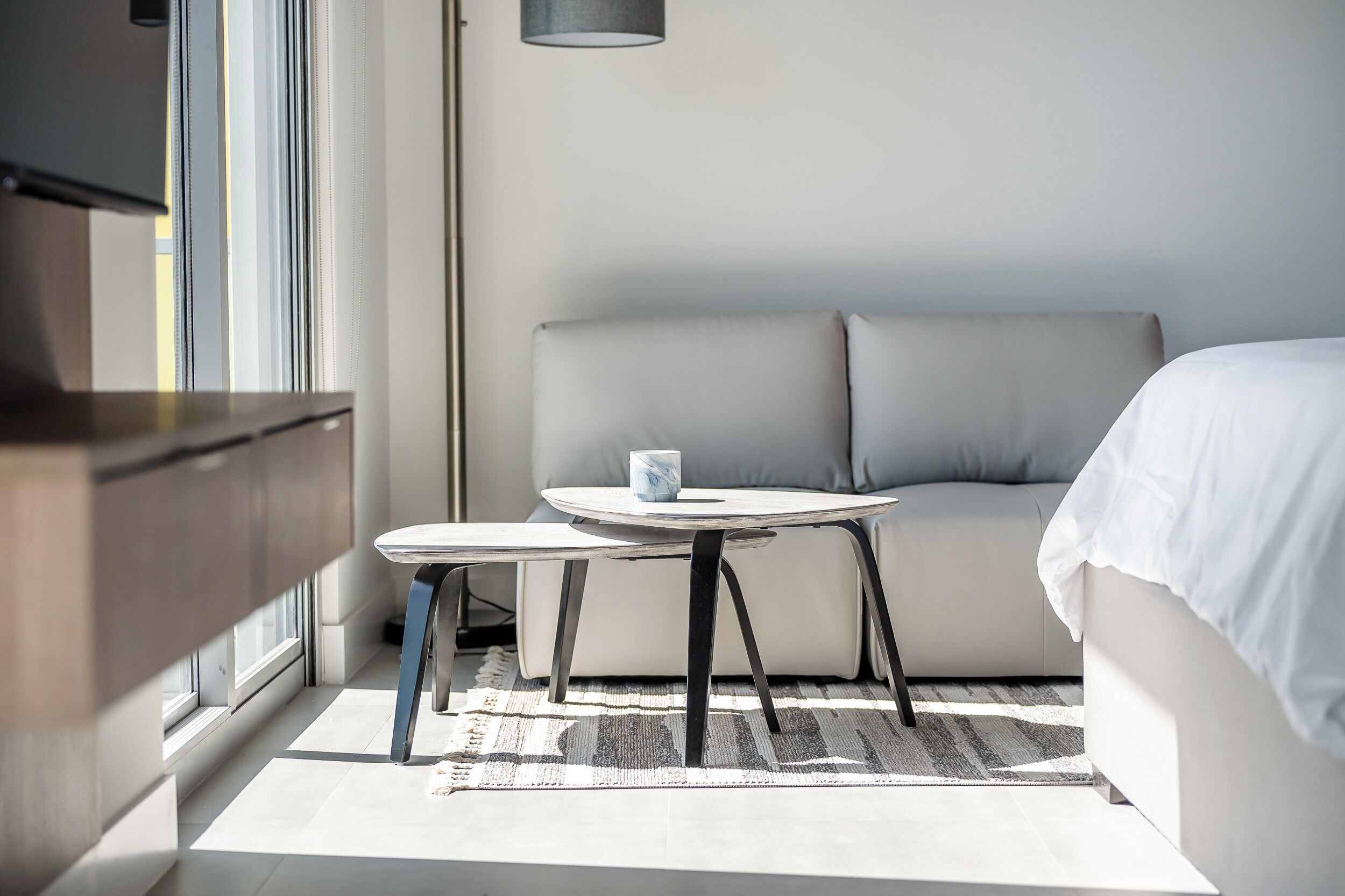 Ein modernes Hotelzimmer mit einem Bett, einem kleinen runden Tisch und einer Couch.