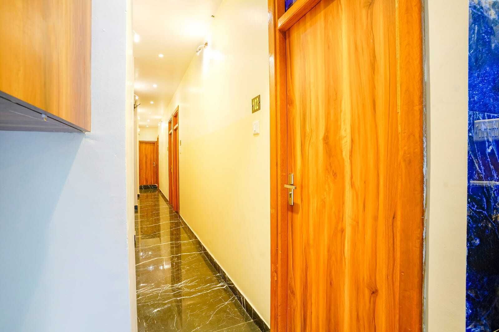 Passadís d'hotel amb portes de fusta i un sòl de marbre.