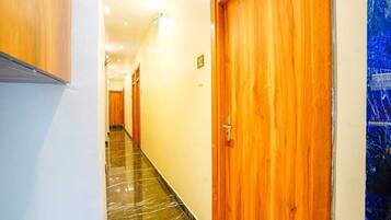 Passadís d'hotel amb portes de fusta i un sòl de marbre.