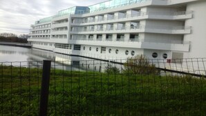Een meerhoog gebouw met balkons en een rivier op de voorgrond.