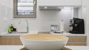 A modern kitchen with a large white sink, a coffee machine, and a window above the sink. - Peris #5 w. Yard steps to Bus St. & Old Town (Chania, Crete)