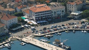 An aerial view of a coastal town with buildings, a marina, and a large ship docked.