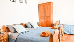 Een slaapkamer met een groot bed, een houten garderobe en een nachtkastje.
