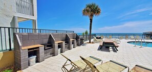 Enjoy al fresco dining and cooking at this outdoor patio, featuring barbecue grills and a casual dining area with lounge chairs and a table.