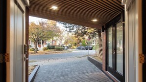 Una entrada techada a un edificio, con un camino de ladrillo que conduce al exterior.