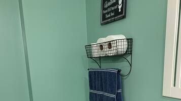Un bagno con un water bianco, un piano di lavoro in granito, un lavandino e un porta asciugamani con un asciugamano blu.