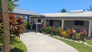 A building with a covered porch, a sign indicating height restriction, and a pathway leading to the entrance. - Bula Retreat (Sigatoka)