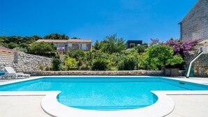 A swimming pool with a stone wall and greenery around. - Nice apartment in Zaton Veliki with WiFi (Zaton Veliki)