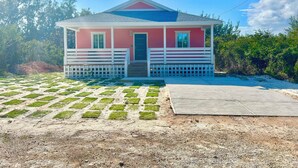 A small pink house with a white porch and a blue roof. - Mama Lou's Hide-A-Way   (Rainbow Bay)
