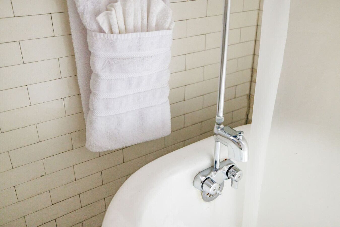 Un baño con un lavamanos blanco, un grifo cromado y una toalla colgada en un toallero de pared.
