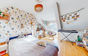 A cozy bedroom with a bed, a desk, a chair, and a keyboard on a stand. - Gorgeous home in Quessoy with WiFi (Quessoy)