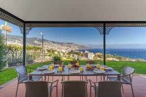 Una mesa dispuesta para el desayuno con vista a la ciudad y al mar.