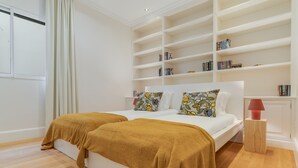 Une chambre à coucher avec un grand lit, une bibliothèque et une table de chevet.