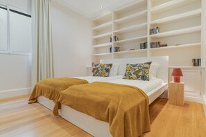 A bedroom with a large bed, a bookshelf, and a bedside table. - Sublime View Villa by Atlantic Holiday (Funchal)
