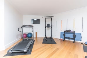 A home gym with a treadmill, weight bench, and various exercise equipment. - Sublime View Villa by Atlantic Holiday (Funchal)