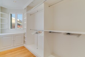 A room with a wooden floor, white walls, a window, a built-in wardrobe, and a shower area with a towel rack. - Sublime View Villa by Atlantic Holiday (Funchal)