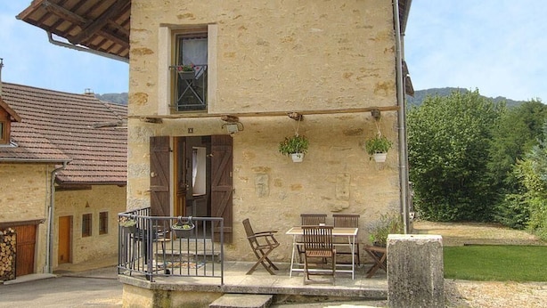 Un edificio de piedra de dos pisos, con un balcón, una puerta y una ventana.