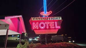 A neon sign for Candlelight Motel with a blue candle design. - Candle Light Motel (Ozark)