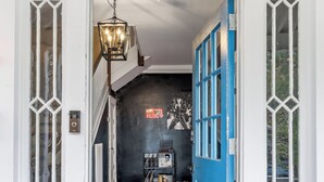 Ein Flur mit Holzboden, einer blauen Tür und einer schwarzen Wand mit einem Neonlicht.