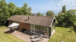 A modern house with a brick exterior, a tiled roof, and a large glass conservatory. - Nice home in Nykøbing Sj with WiFi (Nykøbing Sj)