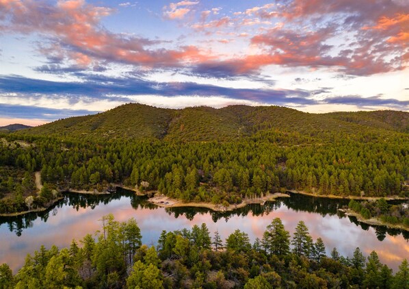 Un paisaje montañoso con un lago rodeado de bosque denso.