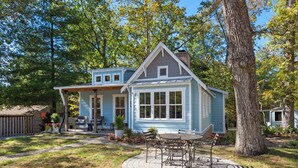 A two-story house with a covered patio area. - Cozy Cottage across the street from Carl Sandburg National Park (Flat Rock)