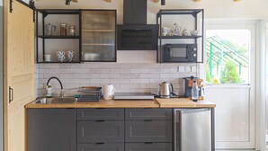 A modern kitchen with a built-in oven, microwave, and coffee machine. There are cabinets and a sink with a dish rack. - Nice home in Sianow with sauna (Sianow)