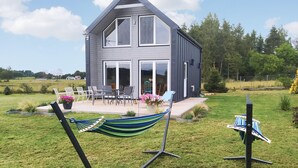 A modern two-story house with a patio, outdoor furniture, and a hammock. - Nice home in Sianow with sauna (Sianow)