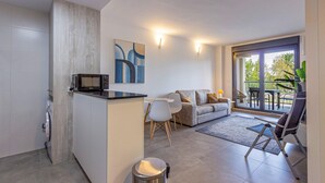 A compact living space with a kitchenette, a sofa, a dining area, and a sliding glass door leading to an outdoor patio. - 1 bedroom lovely apartment in Denia (Denia)