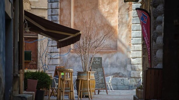 An outdoor seating area with tables and chairs, a chalkboard menu, and a flag. - Apartment 'Appartement Deux Chambres' with Mountain View, Private Terrace and Wi-Fi (Briançon)