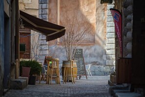 An outdoor seating area with tables and chairs, a chalkboard menu, and a flag.