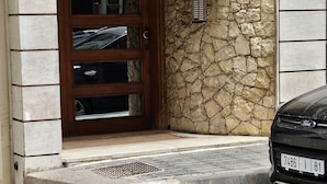 The exterior of El Jomaira, a residence with a stone facade and a wooden door with glass panels.