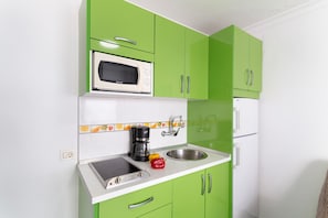 A kitchen with green cabinets, a microwave, a coffee maker, and a sink. - Vacation Apartment 'Los Angeles 3' with Sea View, Shared Terrace and Wi-Fi (Playa de Mogán)