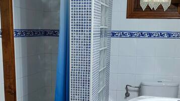 Un bagno con doccia, lavandino e WC.