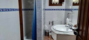 Ein Badezimmer mit Dusche, Toilette, Waschbecken und Spiegel.
