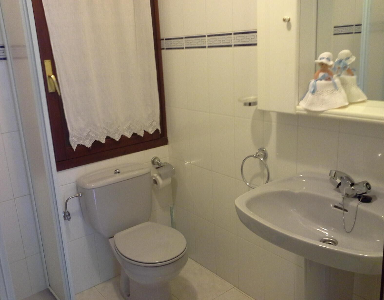 Un baño con inodoro, lavabo y espejo.