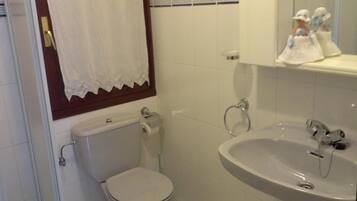 Un baño con inodoro, lavabo y espejo.