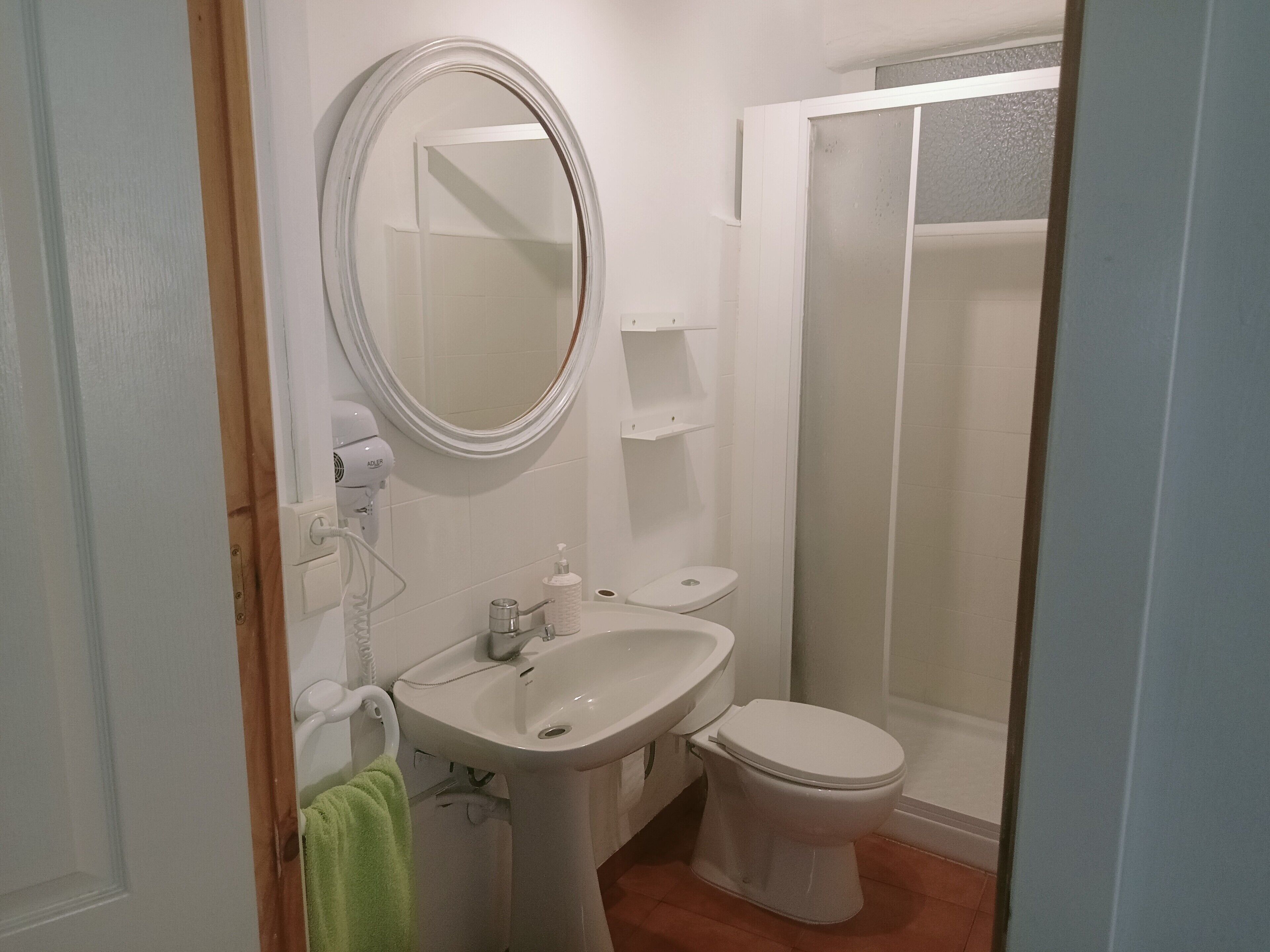 Kylpyhuone, jossa on pesuallas, wc, peili ja suihku.