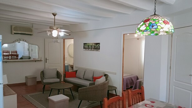 A living room with a sofa, chairs, a table, a ceiling fan, and a stained glass light fixture. - Rural house 'Casa Rural San Antón' with mountain views (Quesa)