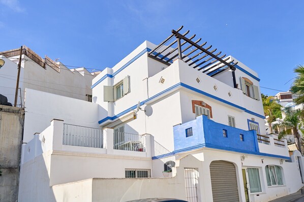 Un edificio a più piani con balconi, un basculante per garage e un'antenna parabolica.