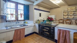 A kitchen with a sink, stove, and cabinets.