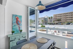 Un balcón con vistas a un edificio y coches estacionados.
